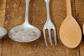 fork and summer, cast aluminum cutlery on rustic wooden table. Traditional kitchen utensil in Brazil