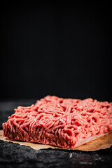 Poster - Raw minced meat on paper on the table. 