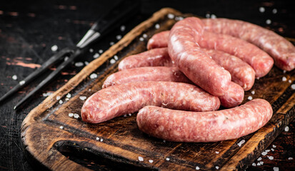 Poster - Raw sausages on a cutting board. 