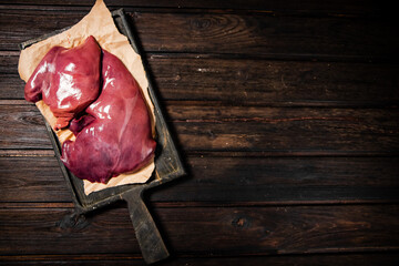 Poster - Raw liver on a cutting board on paper. 