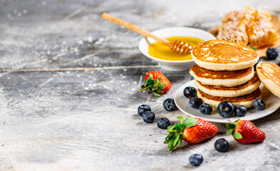 Wall Mural - Pancakes in a plate with berries and honey. 