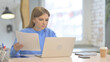 © stockbakers - Woman Working on Laptop and Documents