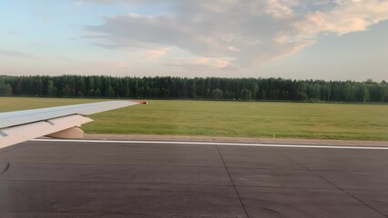 Aufkleber - The plane is dressed for takeoff. Aircraft's wing and land seen through the illuminator. View from the window of the plane. Airplane, Aircraft. Traveling by air. Airplane flight at sunset or dawn. 