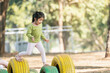 Cute asian girl smile play on school or kindergarten yard or playground. Healthy summer activity for children. Little asian girl climbing outdoors at playground. Child playing on outdoor playground.