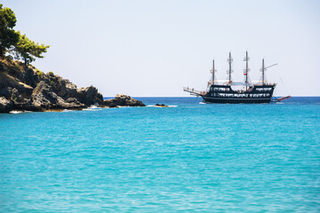 Wall Mural - Beautiful sea coast with turquoise water and touristic ship near Alanya, Turkey. Summer landscape. Summer holiday adventure, active vacation concept.