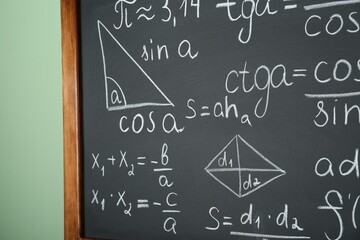 Wall Mural - Chalkboard with many different math formulas on green wall, closeup