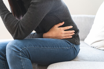 close up woman suffering stomach pain from food poisoning.