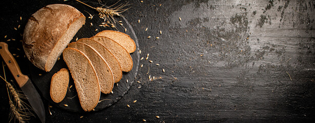 Canvas Print - Slices of fresh bread on a stone board. 