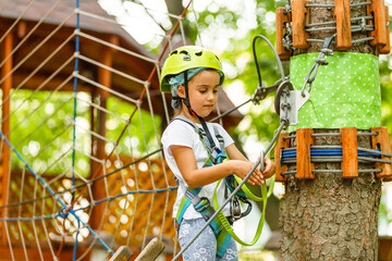 Happy little girl climbing on outdoor playground