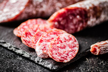 Pieces Of Salami Sausage On A Stone Board. 