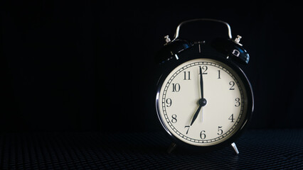 Background photo of an alarm clock showing 7:00