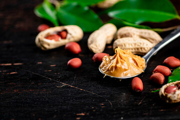 Poster - A spoonful of peanut butter on a table with leaves.