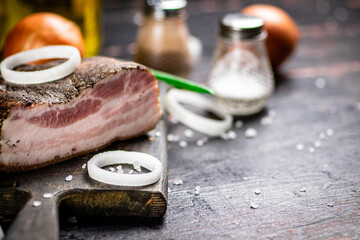 Poster - A piece of pork ladr with onion rings on a cutting board. 