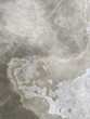 Smooth cement floor with random swirls of discoloration and small surface cracks abstract vertical background texture