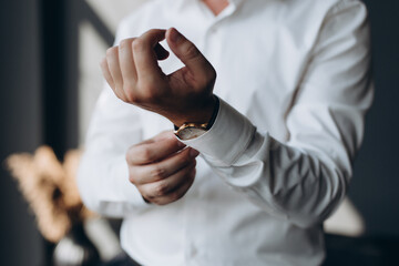 Wall Mural - businessman checking time on his wrist watch, man putting clock on hand,groom getting ready in the morning before wedding ceremony