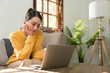 © wichayada - Portrait of a young happy female sitting on the couch and working on project, watching movie on laptop, studying, blogging, resting and chatting online.