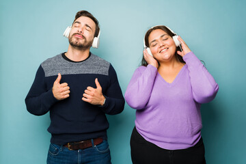 Wall Mural - Happy relaxed couple listening to music with headphones