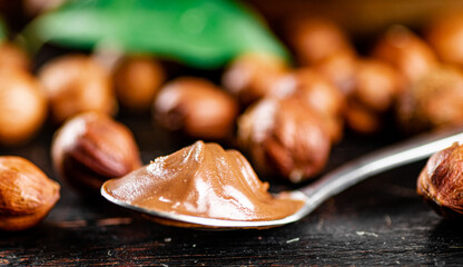 Canvas Print - Hazelnut butter in a spoon on the table. 