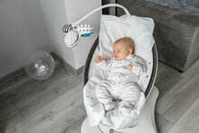 Adorable Baby Sleeps In Baby Rocker In Room. Newborn Concept.