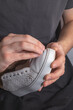 © alexey_arz - Shoemaker's hands sanding an old sneaker with sandpaper before painting. Shoe repair. Close-up