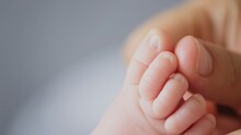 Macro Shot Of Infants Toe. Mother Touching Her Small Child's Toes While He Is Asleep. Slow Motion Video Of Mother Touching Her Sons Feet. Mum Cares Of Her Infant Baby. 