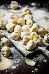 Poster - Homemade dumplings on a cutting board with flour. 