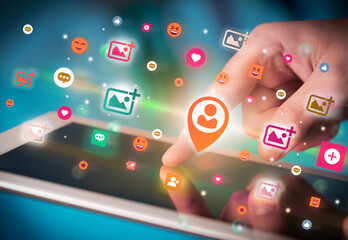 Close-up of a hand using tablet with social media icons