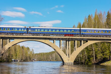 Passenger Train On A High Old Railway Bridge Over The River