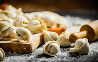 Poster - Raw dumplings on a wooden cutting board.