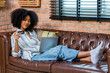 © kanpisut - Young woman consumer holding credit card and laptop buying online at home. Woman shipping online with credit card in hand. Women using laptop technology paying credit card shopping online