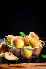 Wall Mural - Fresh pears with leaves in a colander. 