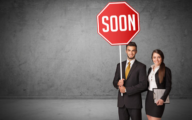 Young business person holding road sign