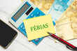 A palavra Férias escrita em um pedaço de papel que está sobre uma calculadora. Notas do Real Brasileiro na composição. Economia brasileira.
