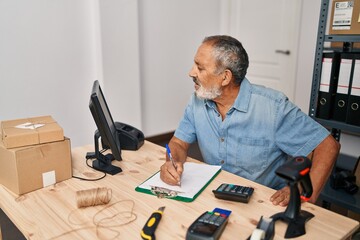 Sticker - Senior grey-haired man ecommerce business worker using computer writing on document at office