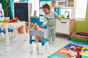 Wall Mural - Adorable hispanic toddler playing with play kitchen and toys at kindergarten