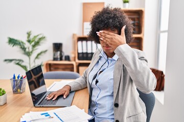 Sticker - Black woman with curly hair wearing call center agent headset at the office covering eyes with hand, looking serious and sad. sightless, hiding and rejection concept