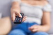 © Krakenimages.com - Young beautiful hispanic woman using tv remote control sitting on sofa at home