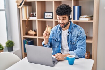 Poster - Arab man doing video call using computer laptop smiling with an idea or question pointing finger with happy face, number one