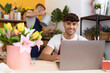 © Krakenimages.com - Two hispanic men florists using laptop watering plant at flower shop