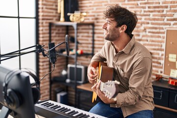 Poster - Young man musician singing song playing classical guitar at music studio