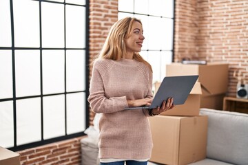 Poster - Young woman smiling confident using laptop at new home