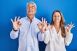 © Krakenimages.com - Middle age hispanic couple standing over blue background relaxed and smiling with eyes closed doing meditation gesture with fingers. yoga concept.