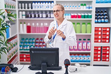 Poster - Young caucasian woman working at pharmacy drugstore disgusted expression, displeased and fearful doing disgust face because aversion reaction. with hands raised