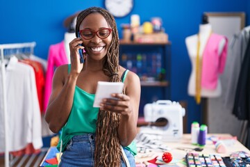 Poster - African american woman tailor talking on smartphone reading notebook at atelier