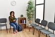 © Krakenimages.com - Young hispanic woman using touchpad sitting on chair at waiting room