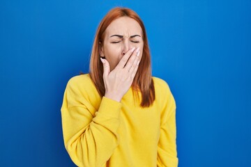 Sticker - Young woman standing over blue background bored yawning tired covering mouth with hand. restless and sleepiness.