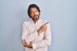 © Krakenimages.com - Handsome middle age man wearing elegant shirt background pointing with hand finger to the side showing advertisement, serious and calm face