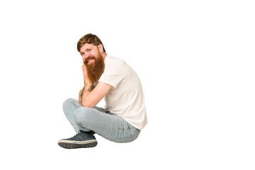 Adult redhead man sitting on the floor isolated