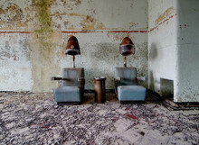 Two Vintage, Abandoned Hairdryer Chairs With A Rusty Ashtray 