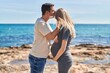 © Krakenimages.com - Man and woman couple standing together touching belly kissing at seaside